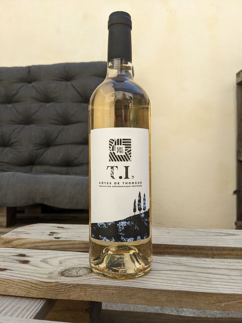 Bouteille de la cuvée T. I., viognier du domaine Les Robes Noires, posée sur une table en bois.
